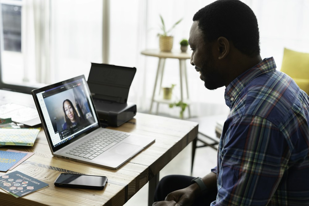 Aprendizaje online con acompañamiento en vivo Persona conversando por videollamada desde una computadora portátil